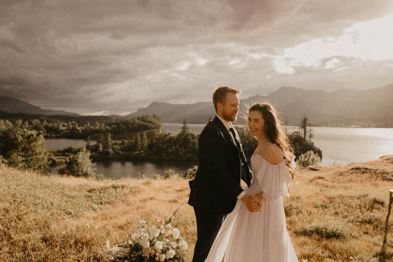 elopement bride and groom standing in a field with mountains on the horizon