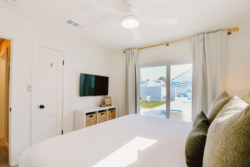 King bed with white linens and green pillows
