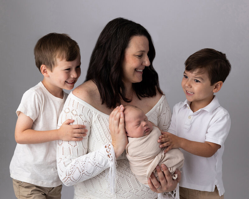 Mom with sons laugh for their family session.