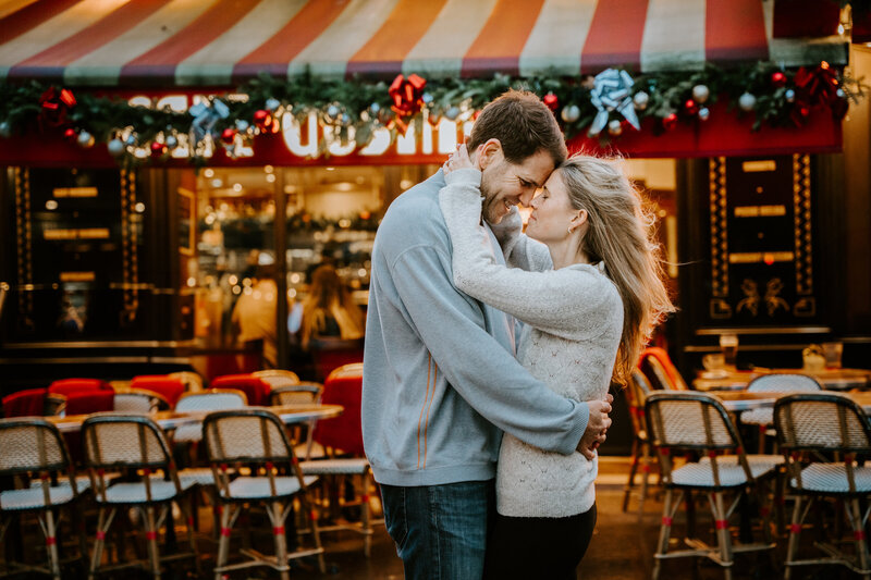 Couple having photo session in front of Cafe Gustave in Paris in winter