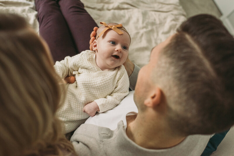 newborn baby looking up at her dad