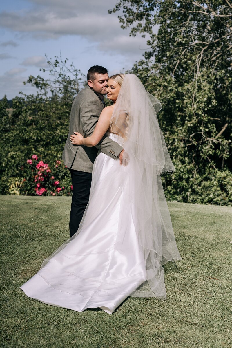 bride and groom standing in a sunny garden in gore new zealand