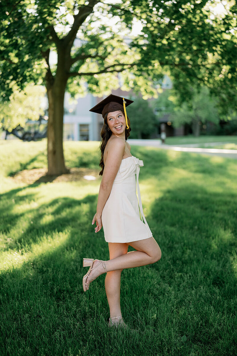 College senior smiling over her shoulder while wearing her graduation cap at Western Michigan University.