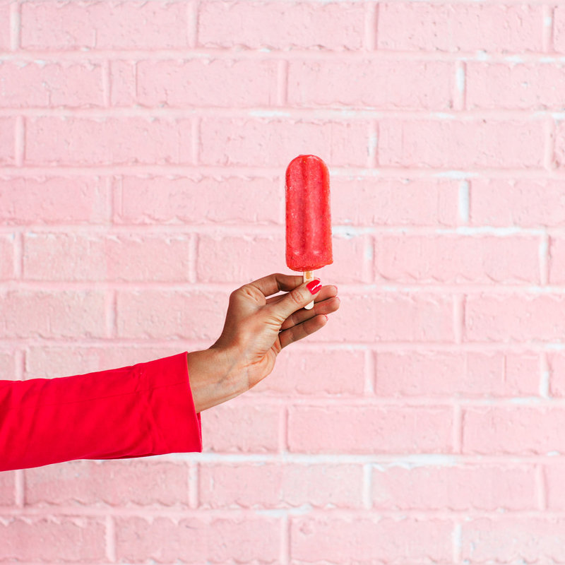 woman holding a red popsicle