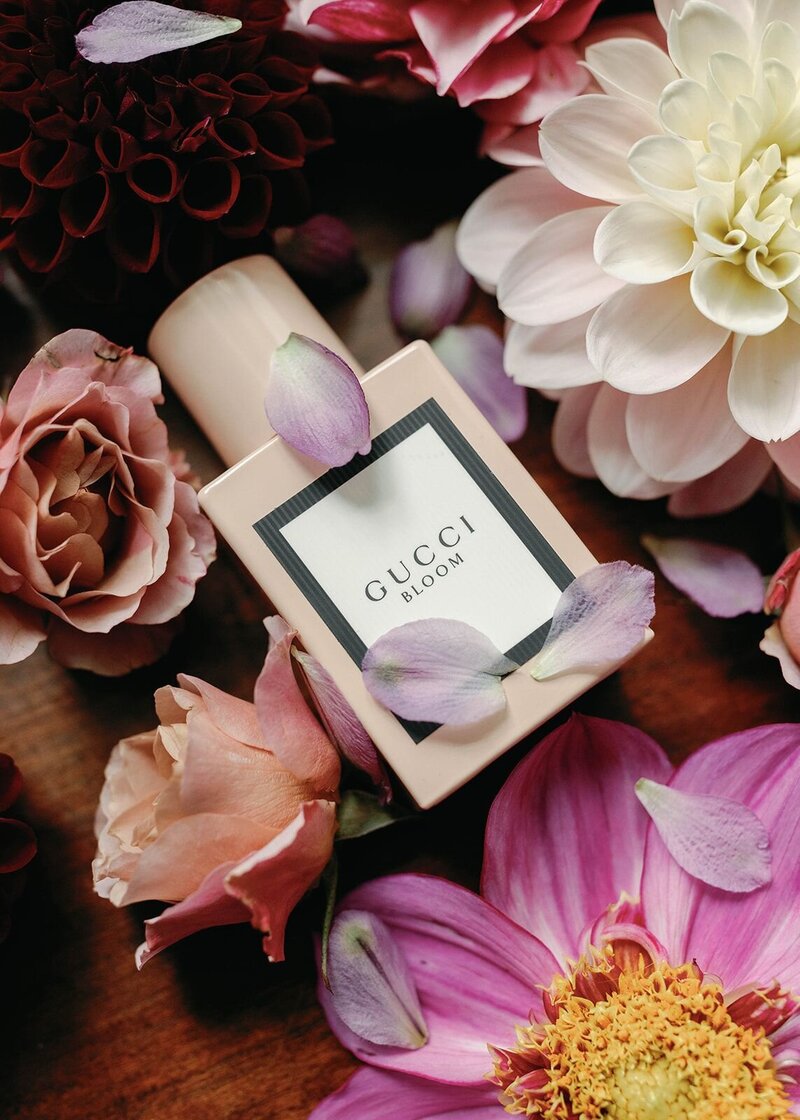 Gucci perfume floral flat lay with roses and dahias