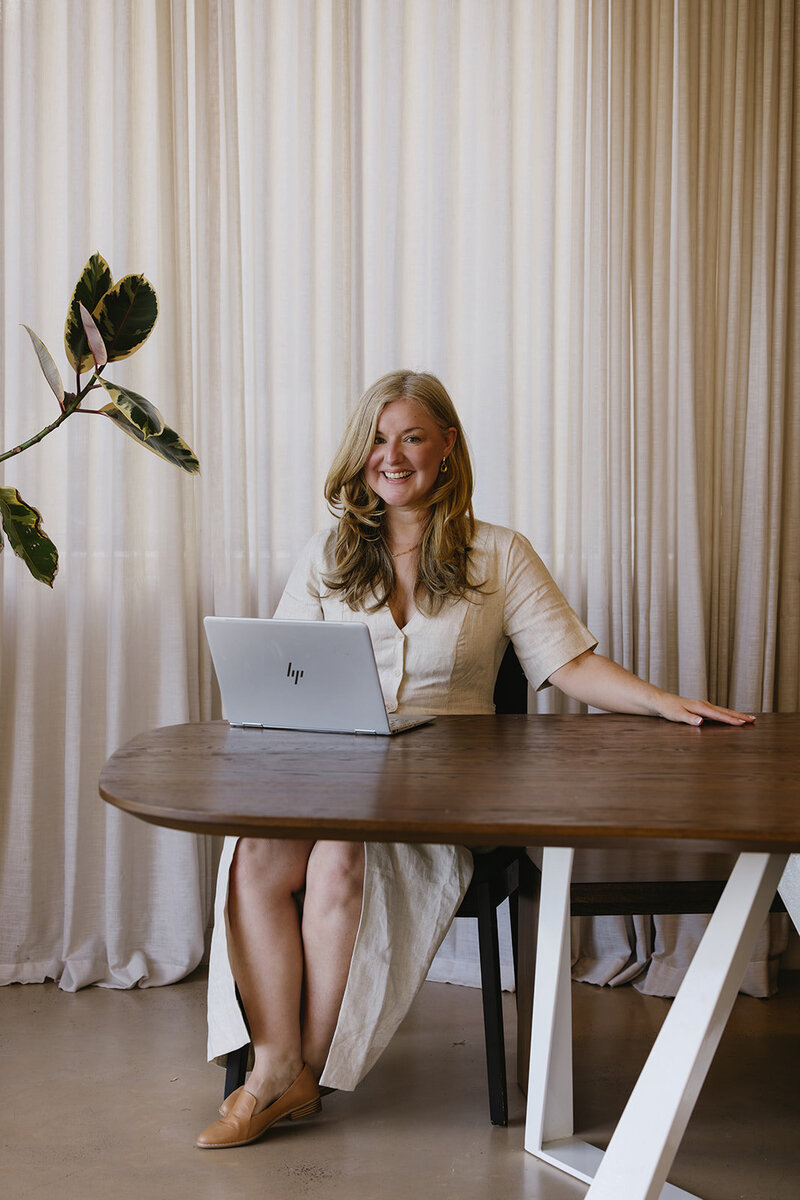 Elaine McDonnell, an Irish–Australian female voice actor based in Melbourne, Australia, sitting at her studio desk with a laptop and microphone. She brings calm clarity, warmth, and grounded expression to narration, brand storytelling, elearning, and creative projects. Founder of The Aligned Empath