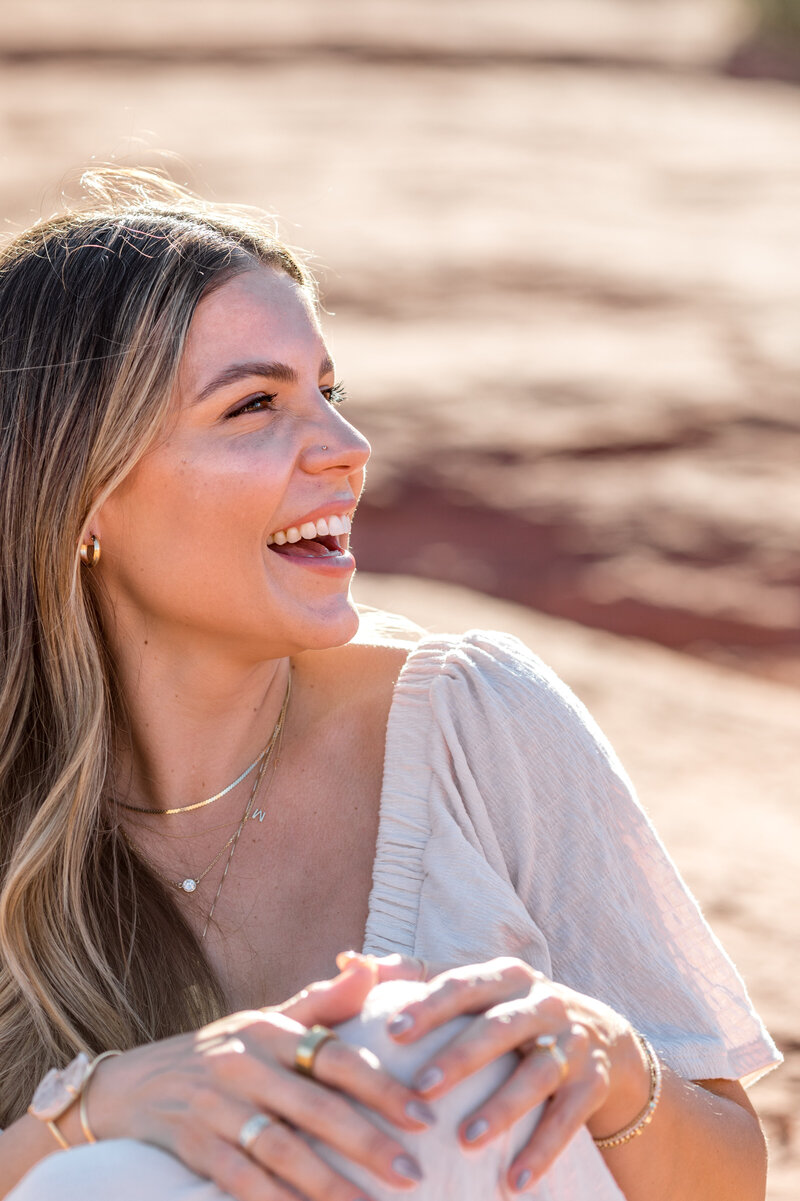 Natalie Bernacchi smiling and laughing outdoors sharing empowering beliefs about women achieving both success and fulfillment, including: building a business and life that reflect true expression, being a powerful CEO and a present mom, and not needing to sacrifice oneself. 
