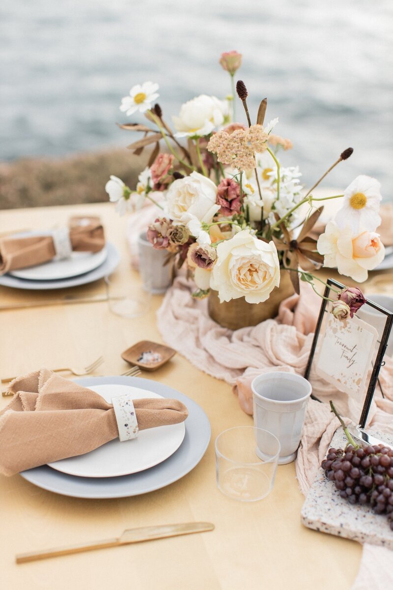 Soft floral centerpiece at a wedding reception overlooking the dramatic Big Sur coastline