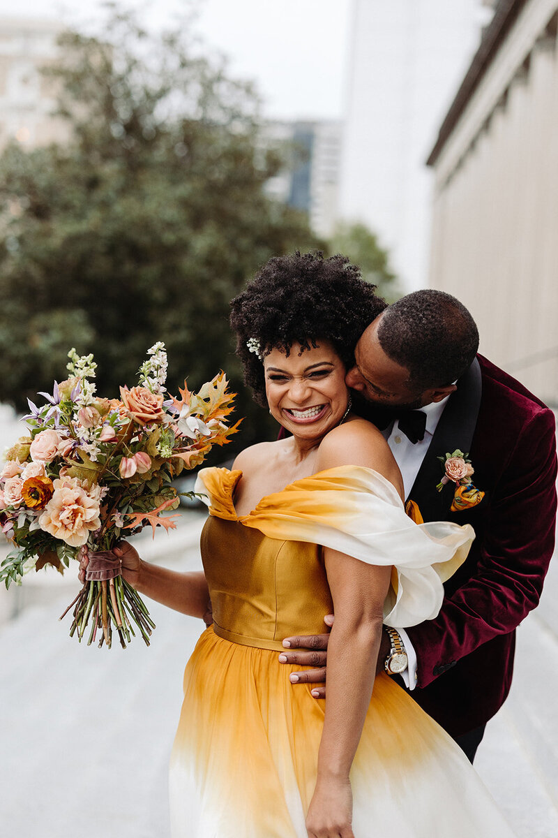 Autumnal bridal bouquet composed of roses, ranunculus, delphinium, clematis, lisianthus, and fall foliage floral hues of burnt orange, mauve, dusty rose, taupe, and lavender. Fall wedding in Downtown Nashville. Design by Rosemary & Finch Floral Design in Nashville, TN. 