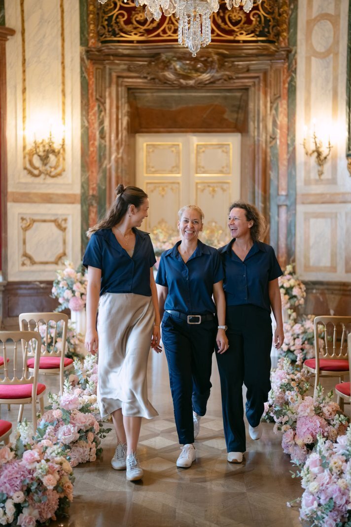 Team of ECLAT Destination Weddings walking down the aisle at the oval room of palace Daun Kinsky ready for the wedding ceremony