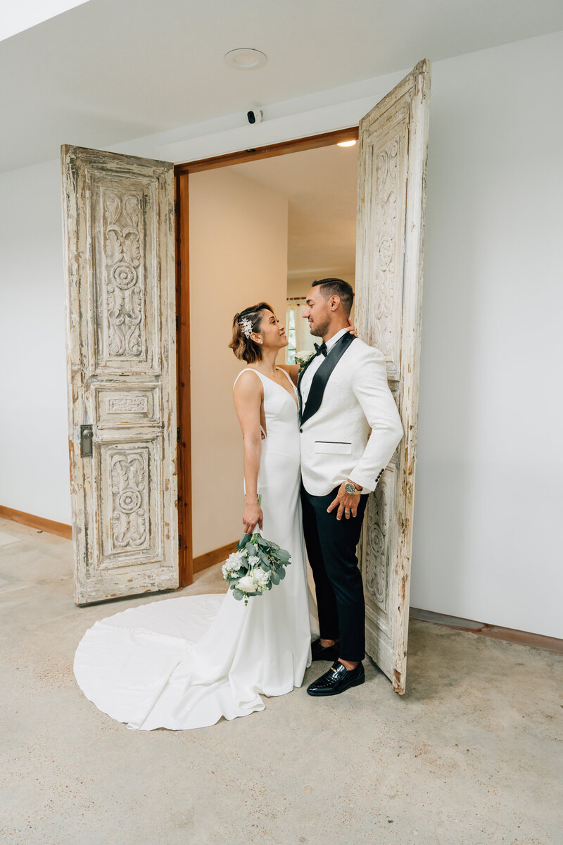 bride and groom looking at each other  resting in the door