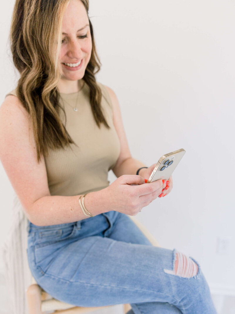 woman with bright nail polish working on her phone