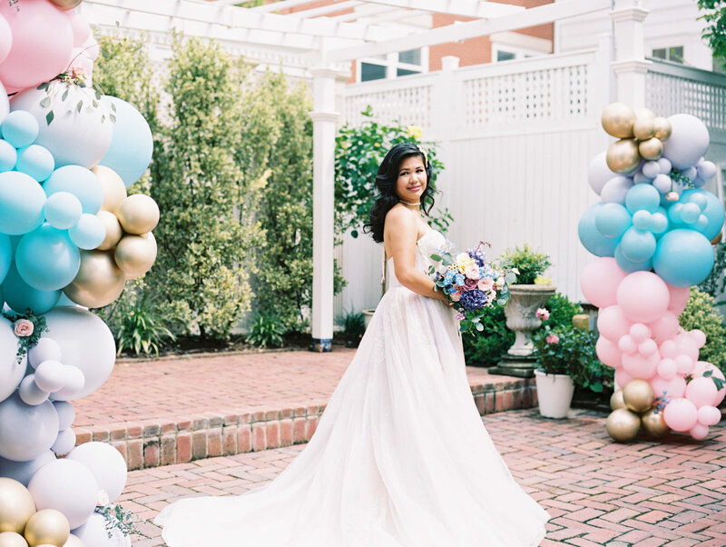bride standing next to colorful balloon arrangements