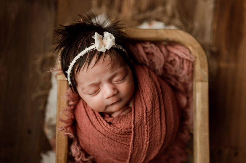 A newborn baby lies on a heart