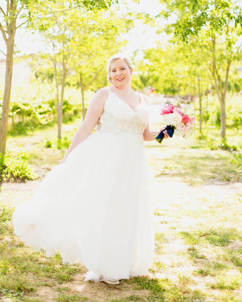 Portrait of Bride holding her bouquet turning as she holds her dress