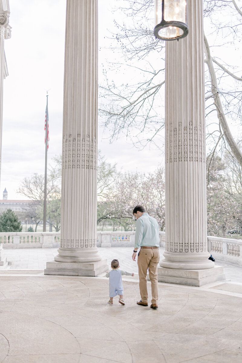 Father and son walking under columns in Washington DC