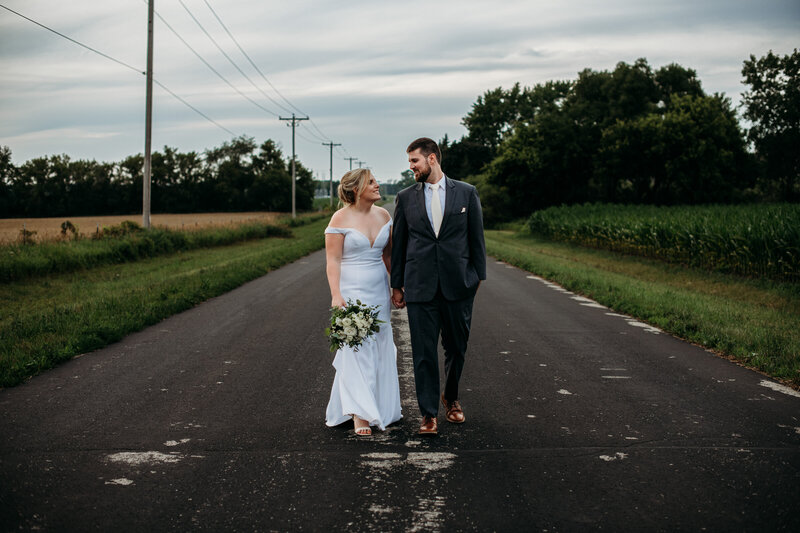 Bride and groom staring at each other in the middle of the street