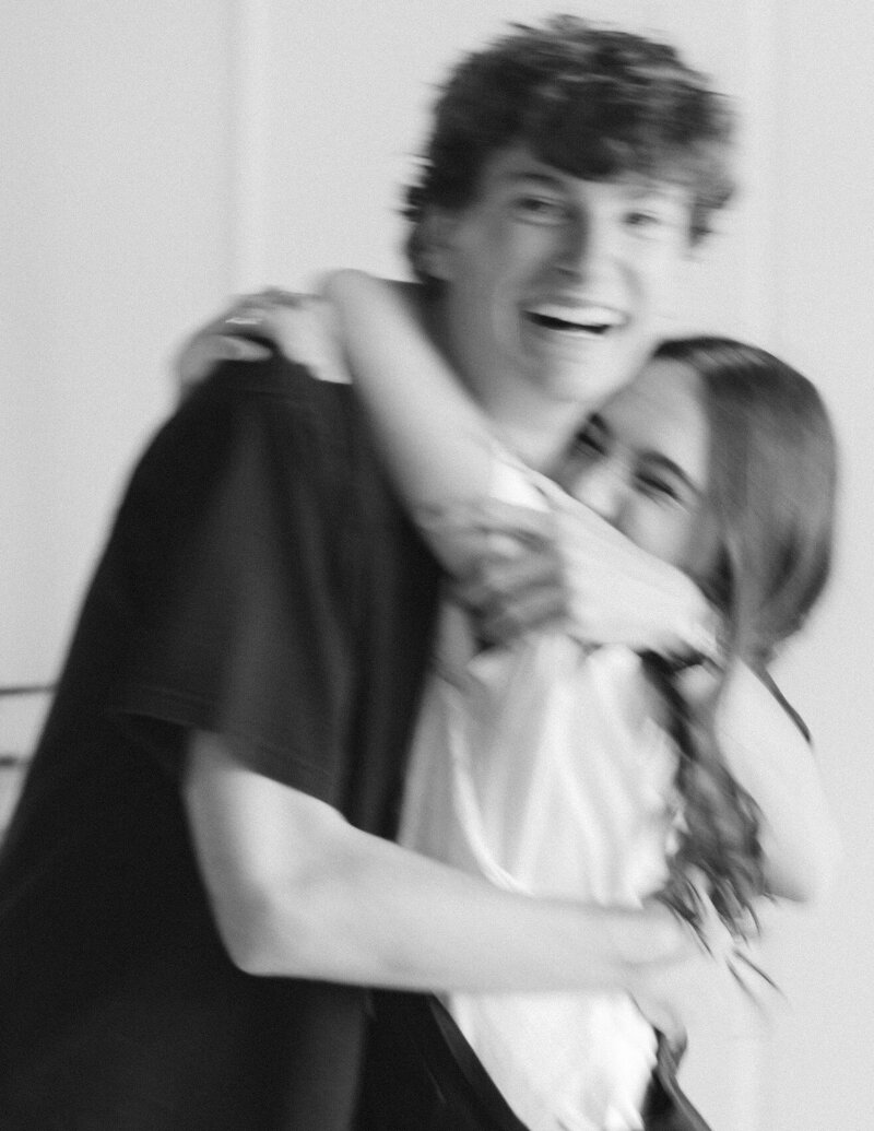 Black and white blurry image of couple with their arms wrapped around each other