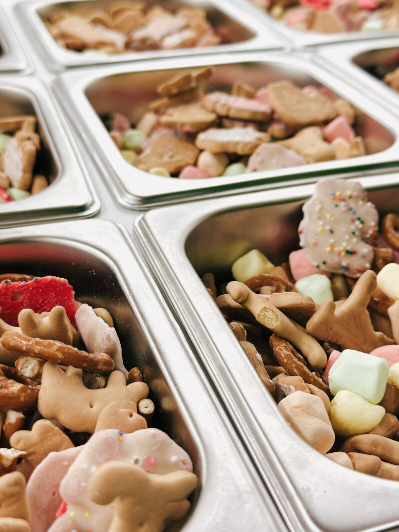 Dessert cart with bins on top holding animal cracker treats.
