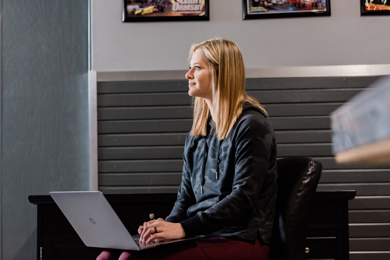 woman sitting in a chair with a laptop in her lap