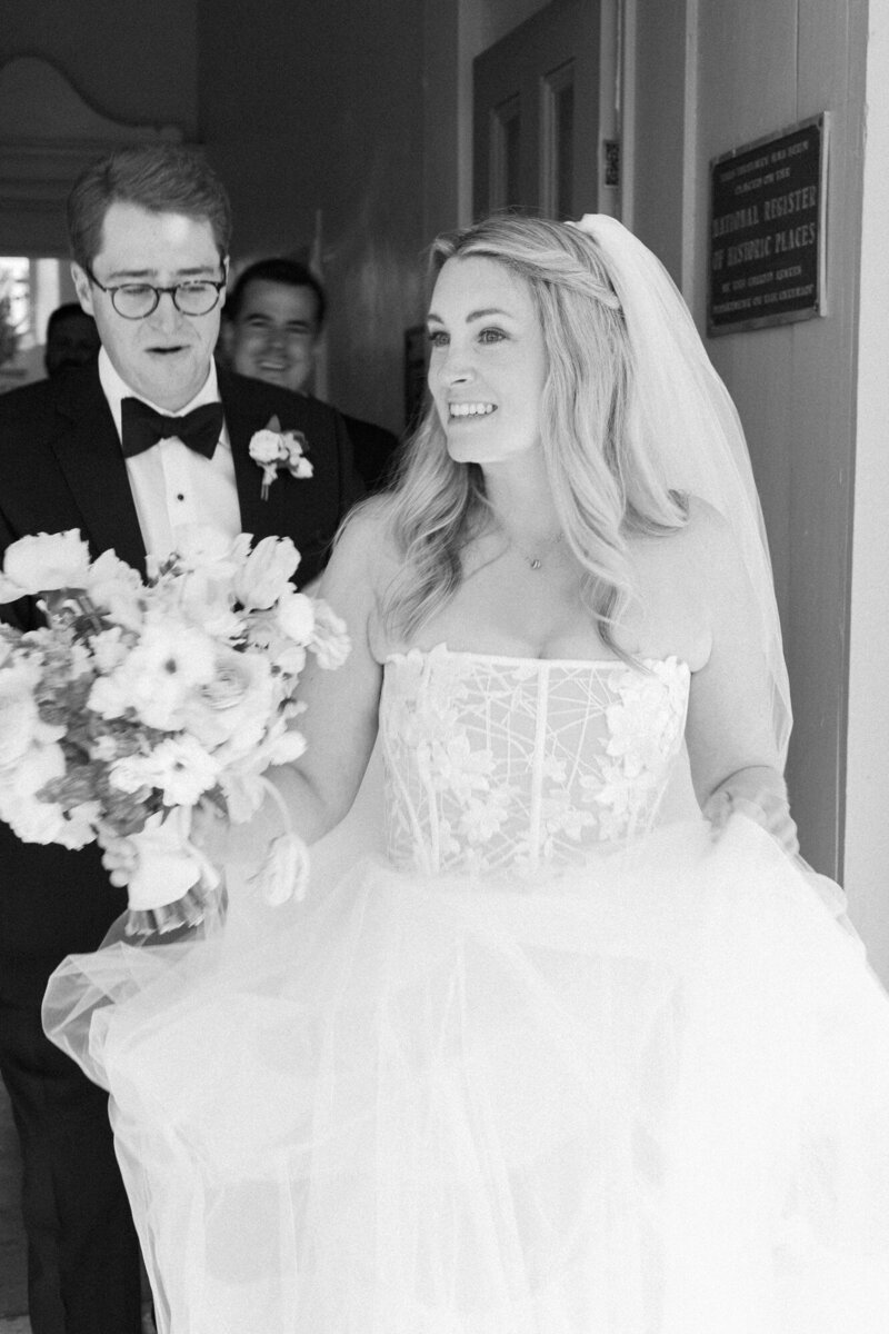 Black and White photo of bride and groom walking out of the chapel at their Bishop's Lodge Wedding.