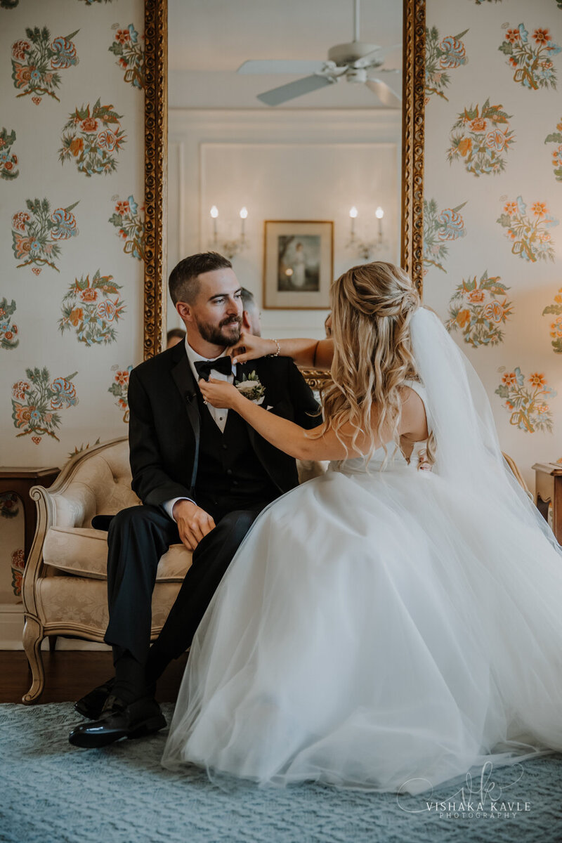 bride and groom smiling at each other while sitting