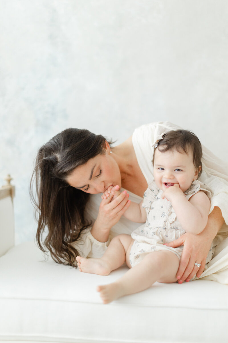 Mother kisses her baby's hand