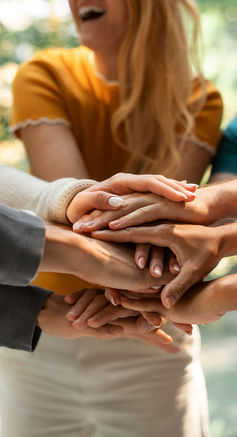 Employés faisant un pacte de solidarité avec les mains dans le cadre d'un team building organisé par une event planner.