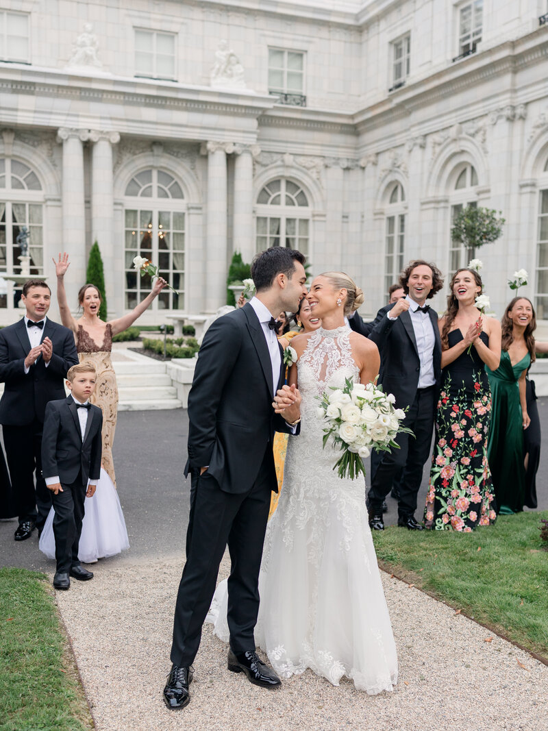 Bride and her parents walk towards the ceremony in front of a Rolls Royce