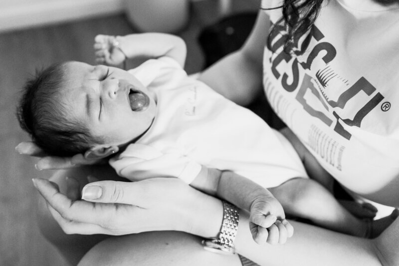 a baby is yawing in her mother's arms