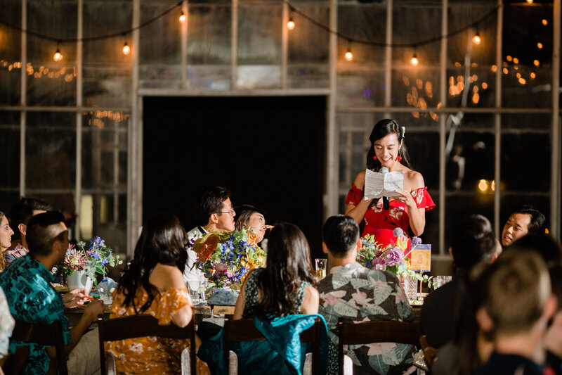 The maid of honor gives her speech to engaged guests in the greenhouse at Dos Pueblos Orchid Farm, a wedding venue in Santa Barbara, California.