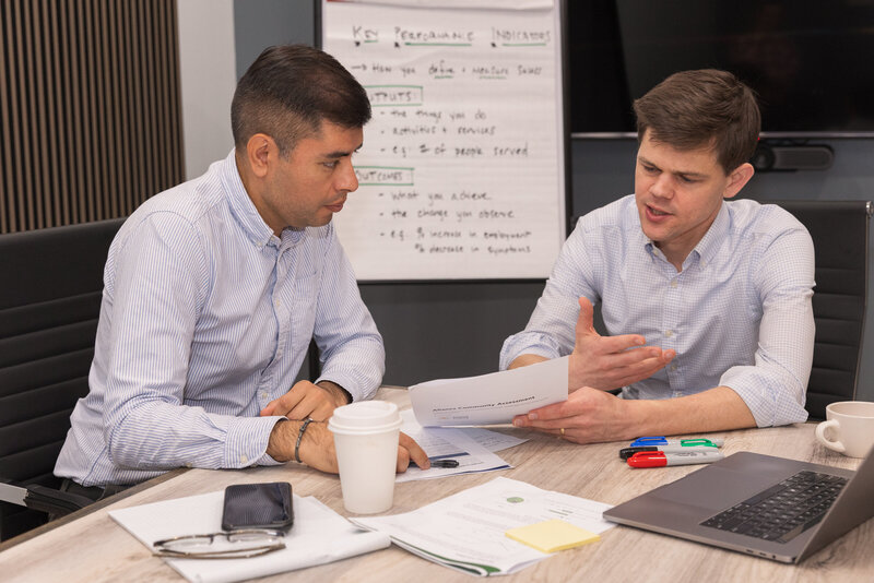 men talking over a document during a meeting on a conference room Atlanta Brand Photographer