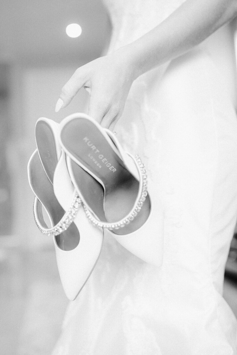 Portrait of a bride holding her wedding shoes while getting ready for her Donovan Pavilion wedding.