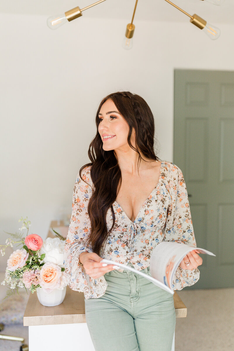 Kali, a wedding and senior photographer in Lewiston, Idaho, smiling in a sunlit outdoor setting.