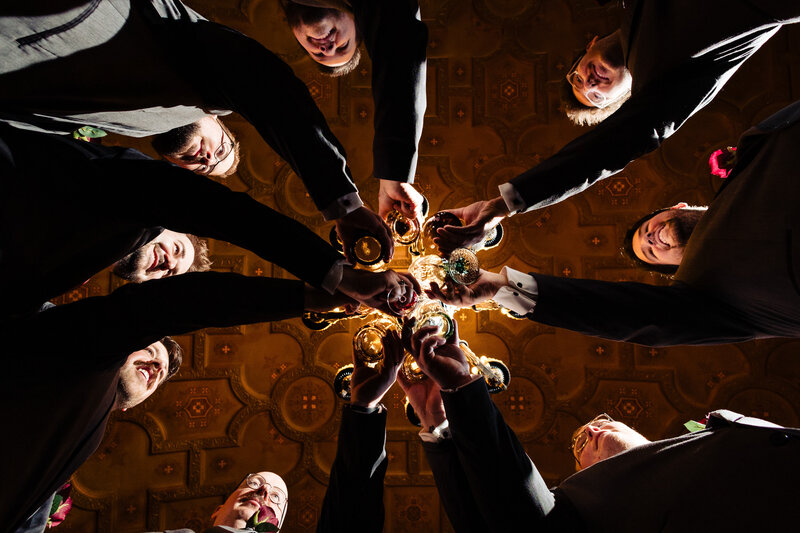 Groom and groomsmen cheers a toast before the ceremony at Toledo Club. Photographed from the floor looking up at the ceiling 