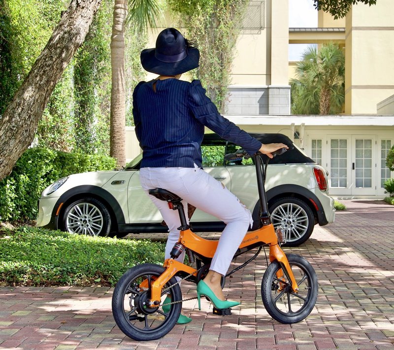 Lady with hat riding Orange Go-Bike M4