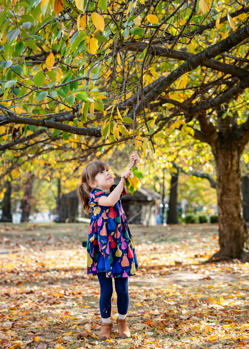 Lifestyle photo of playful girl at an Essex County, New Jersey park in the fall.