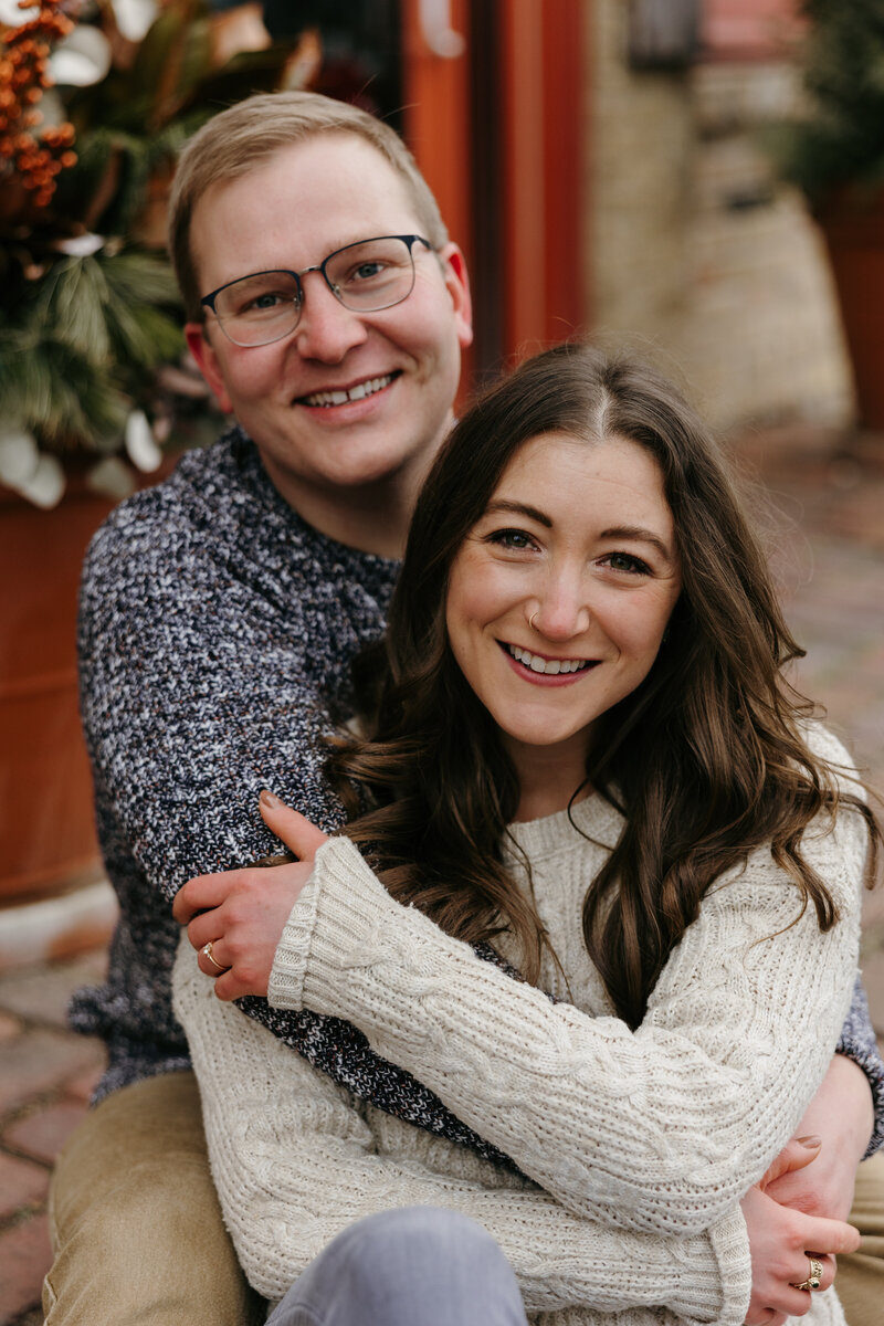 Couple posing for engagement photos with their arms around each other