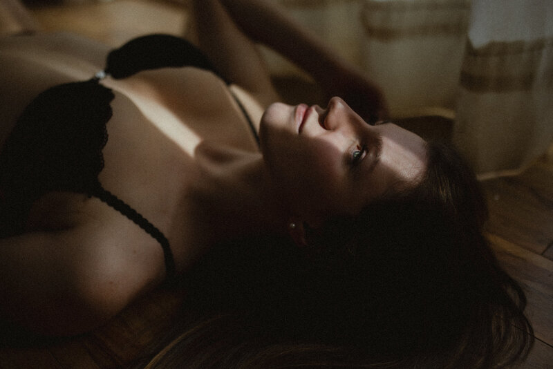girl laying on the floor in a bra with a sliver of sunlight streaming across her face
