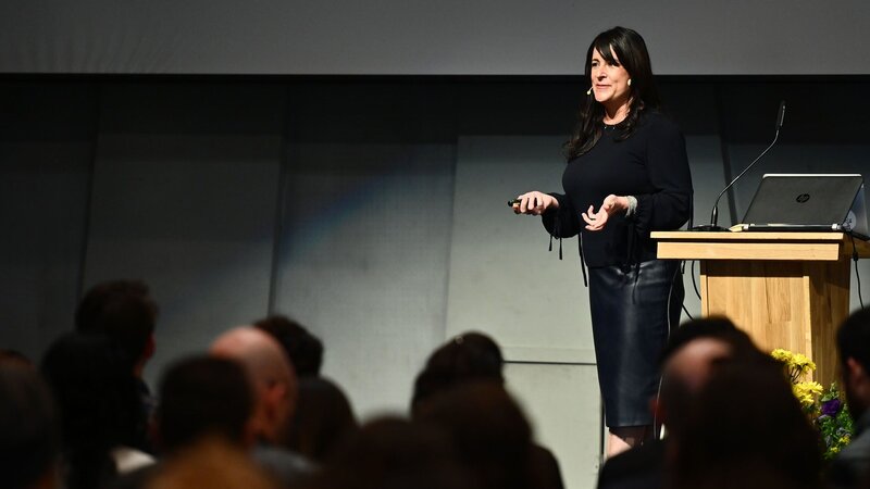 Kristin Skinner delivering a keynote presentation on organizational systems and leadership.