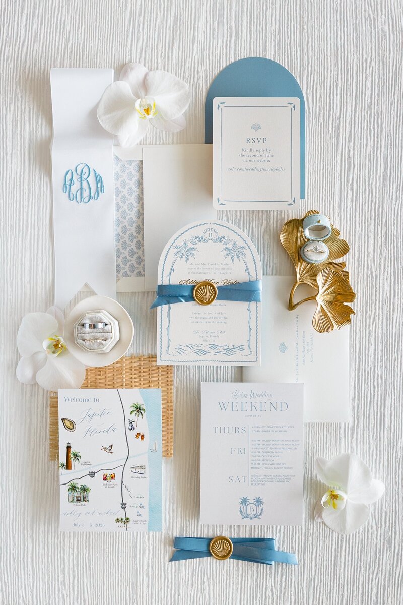 A flat lay of a wedding invitation suite
