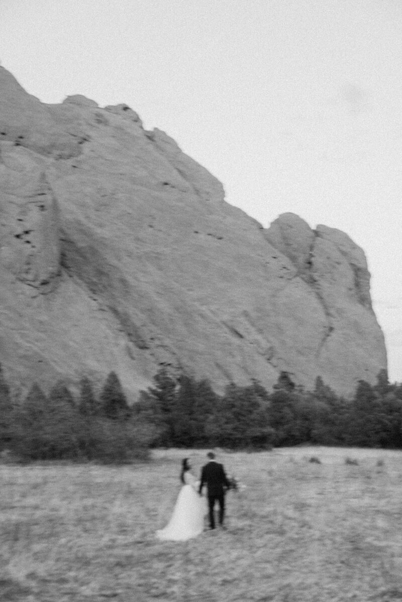 Black and white photo of married couple running at Garden of the Gods
