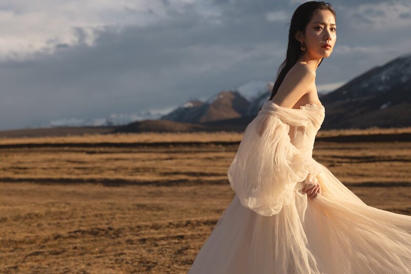 GALIACouture dress bridal shoot on a field with mountains in the background and golden light.LAHAV - BELLINA I