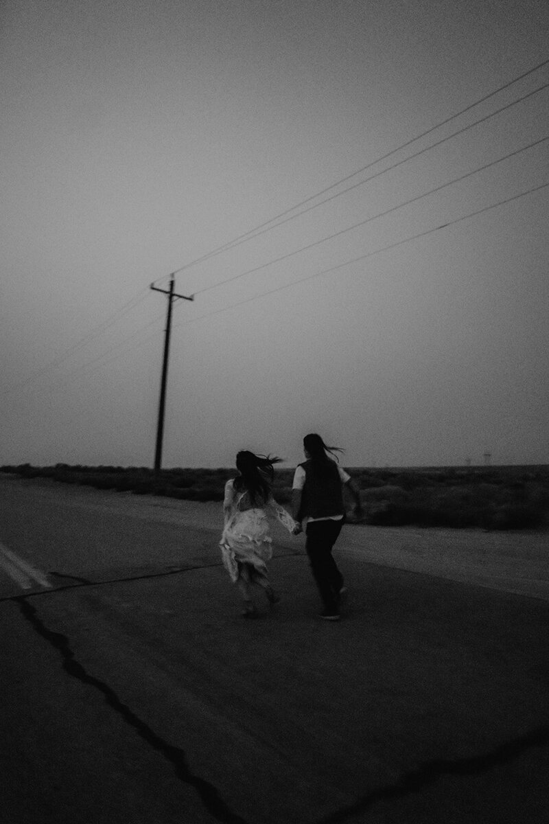 LGBTQ Brides running away from the camera at dusk during their elopement in idaho