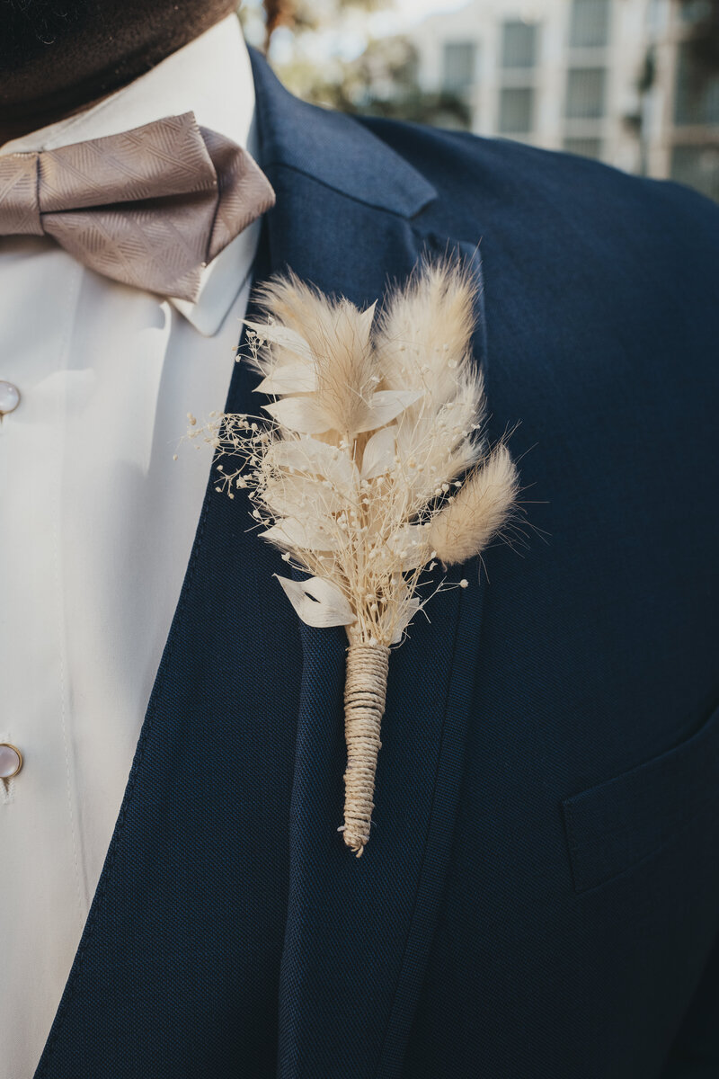 Grooms beige  dried grass boutonniere with blue suit