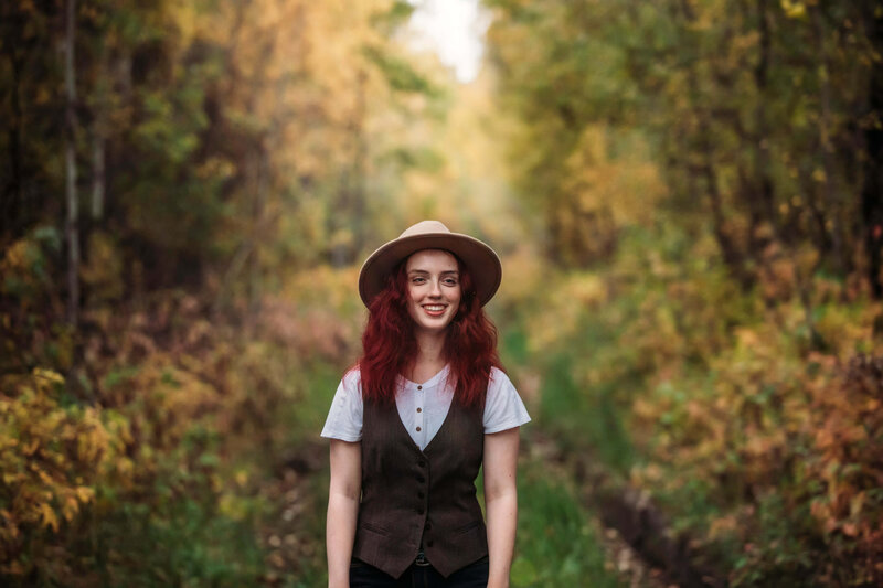 girl with red hair and hat in the fall colours