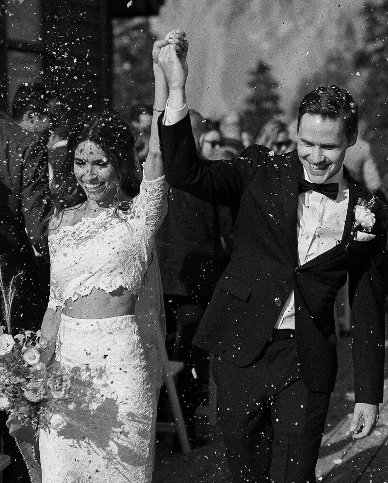 bride and groom walking out of wedding reception celebrating