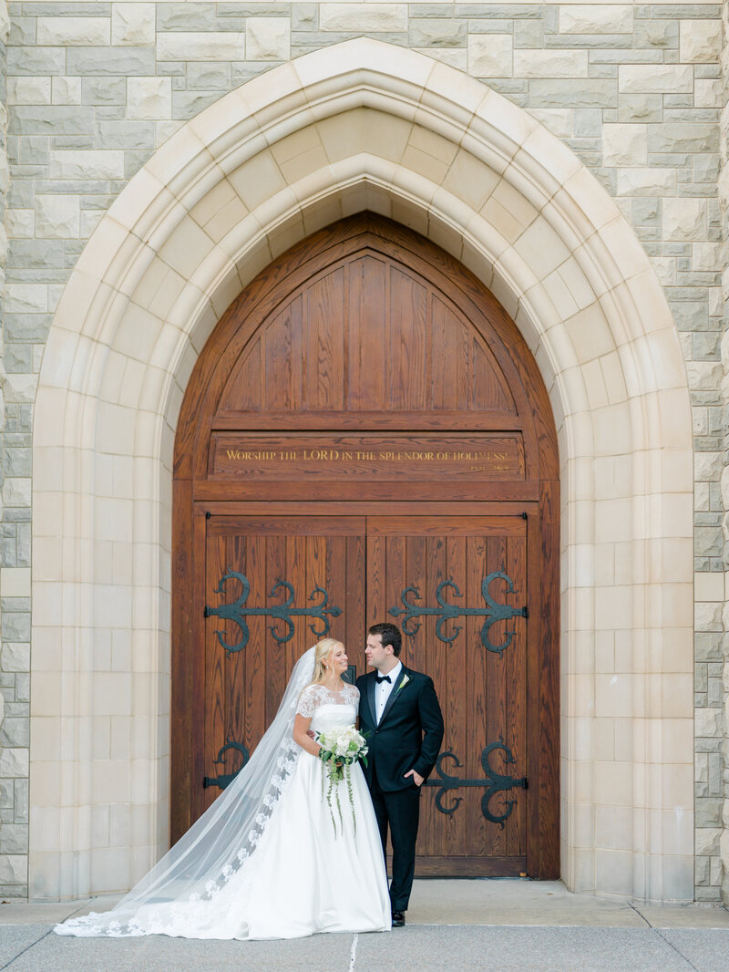 A black and white photo of a married couple standing back to back