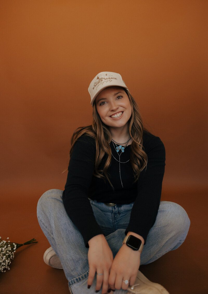 Studio portrait of a Wyoming-based wedding and lifestyle photographer, captured in a clean and professional setup with soft lighting and a relaxed pose.