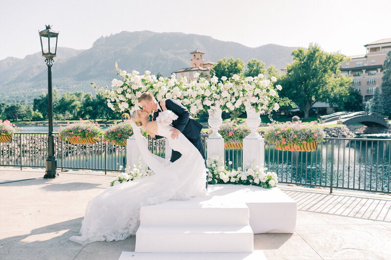 bride and groom embrace in front of mountain range in colorado springs